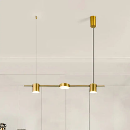Gold-toned modern pendant light with three cylindrical fixtures on a bar, featuring warm white light and rotatable shades