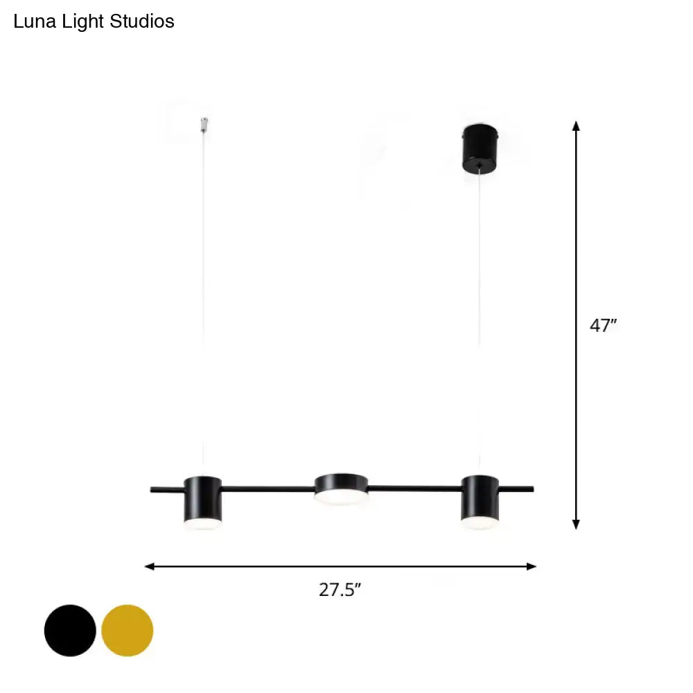 Black cylindrical pendant lights with sleek matte finish and rotatable shade providing warm white light