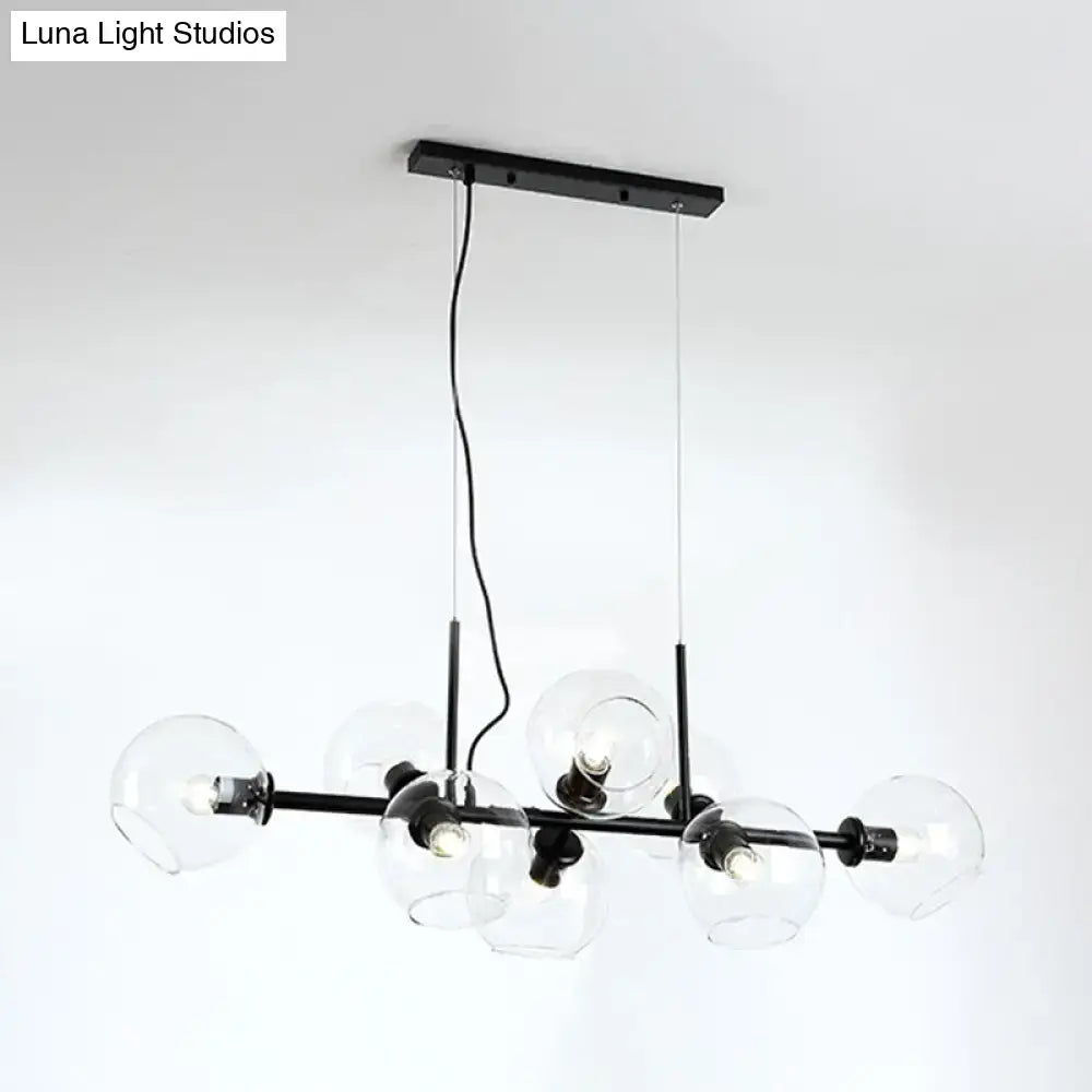 Black metal chandelier with smoky glass globe shades featuring a modern gold and black linear design fixture width