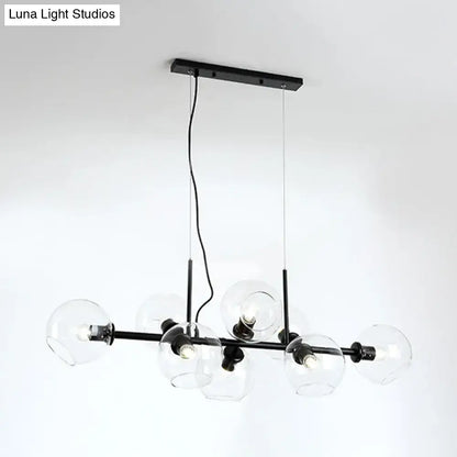 Black metal chandelier with smoky glass globe shades featuring a modern gold and black linear design fixture width