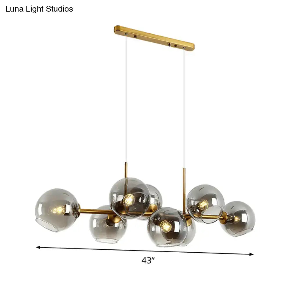 Modern gold and black linear design kitchen island light fixture with smoky glass spheres and adjustable fixture width