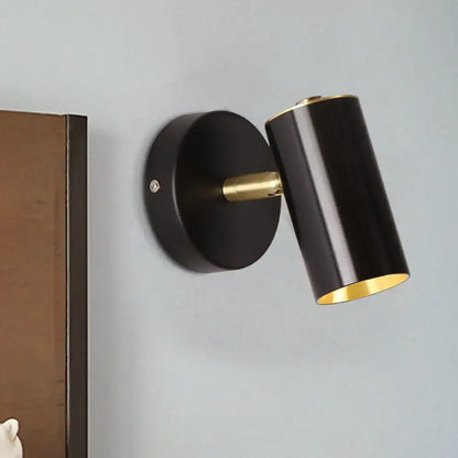 Modern gold and black metallic tube led light bedside wall sconce with black cylindrical body and gold interior brass accents