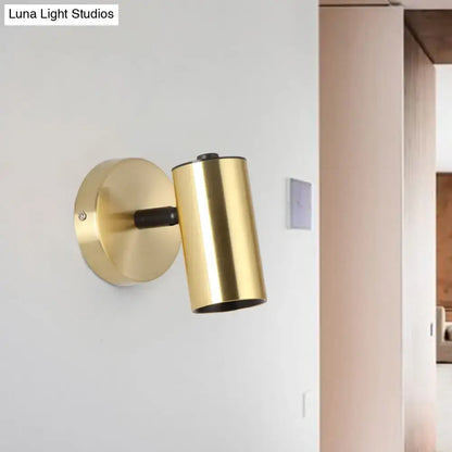 Modern gold and black metallic tube led light bedside wall sconce with gold-finished cylindrical design and matte black accent arm