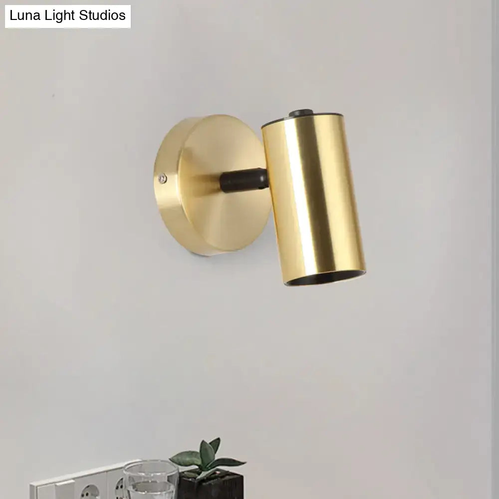 Modern gold and black metallic tube led light bedside wall sconce with a gold-finished cylindrical shade and matte black arm