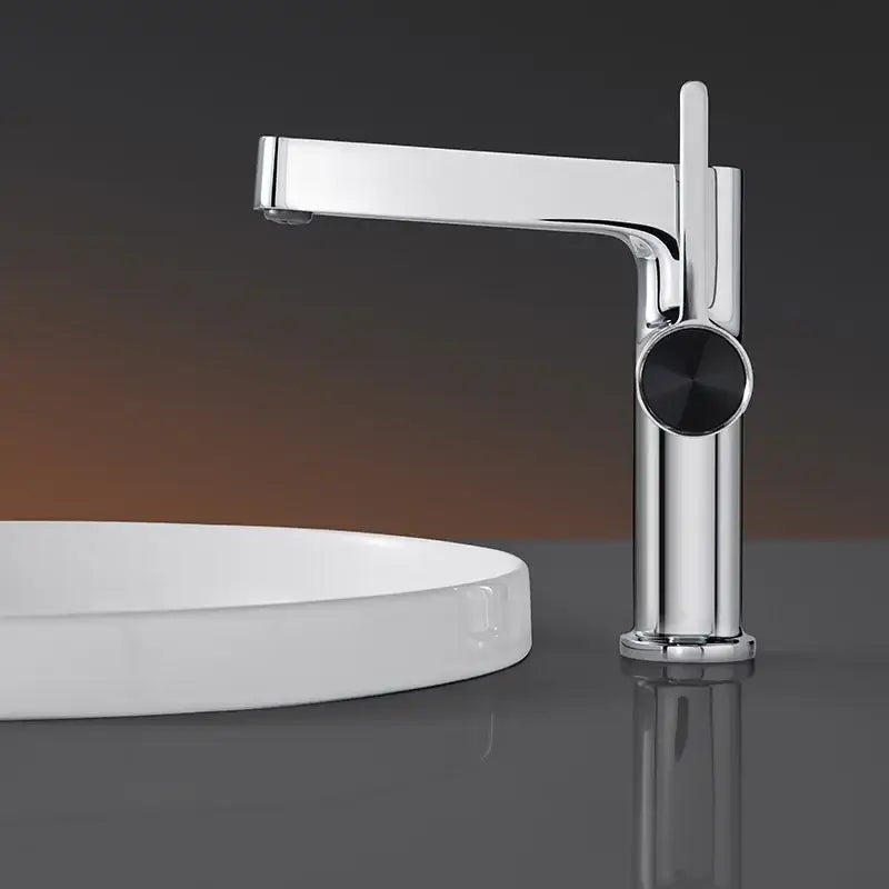 Modern gold and black decorbites basin faucet with sleek chrome body and minimalist black circular handle for bathroom use