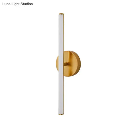Modern gold and black minimalist wall sconce with a cylindrical white diffuser and circular brass base wall light