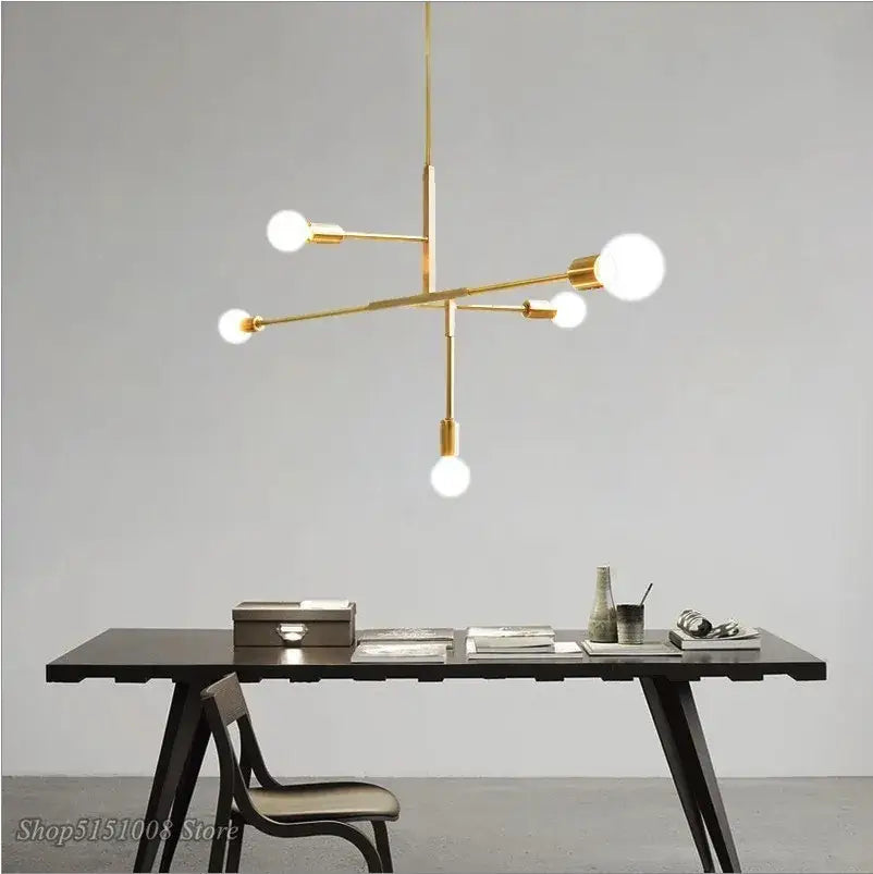 Modern gold and black pendant light with six spherical bulbs in a decorbites cross style for dining room decor