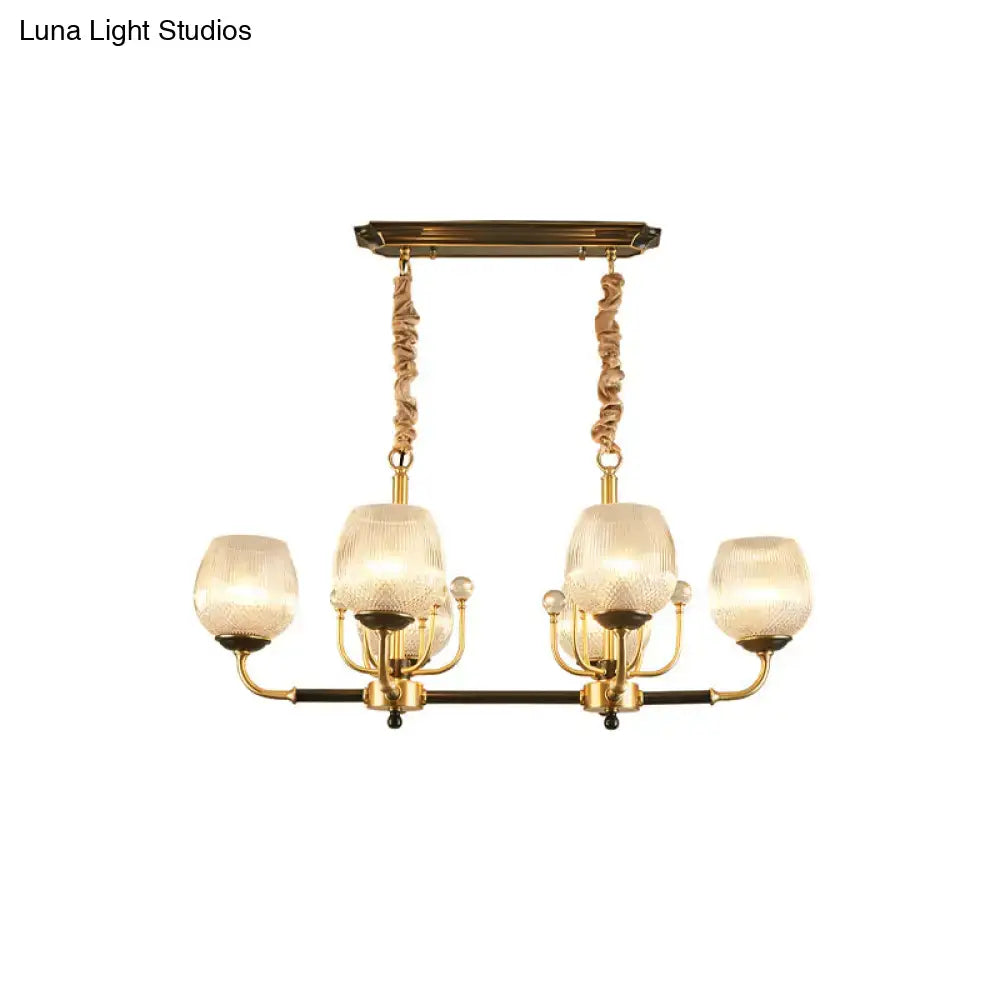 Modern gold and black ribbed glass island chandelier with gold-toned frame and four frosted ribbed glass shades suspended by twisted cords