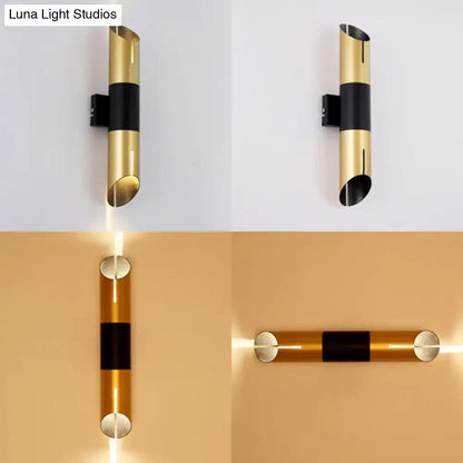 Modern gold and black rotatable cylinder wall sconce with sleek minimalist design for bedroom lighting