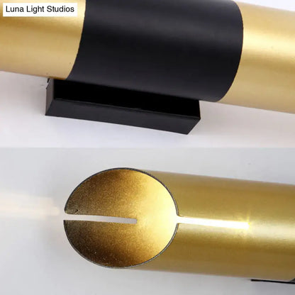 Modern gold and black rotatable cylinder wall sconce with a sleek minimalist design for bedroom lighting