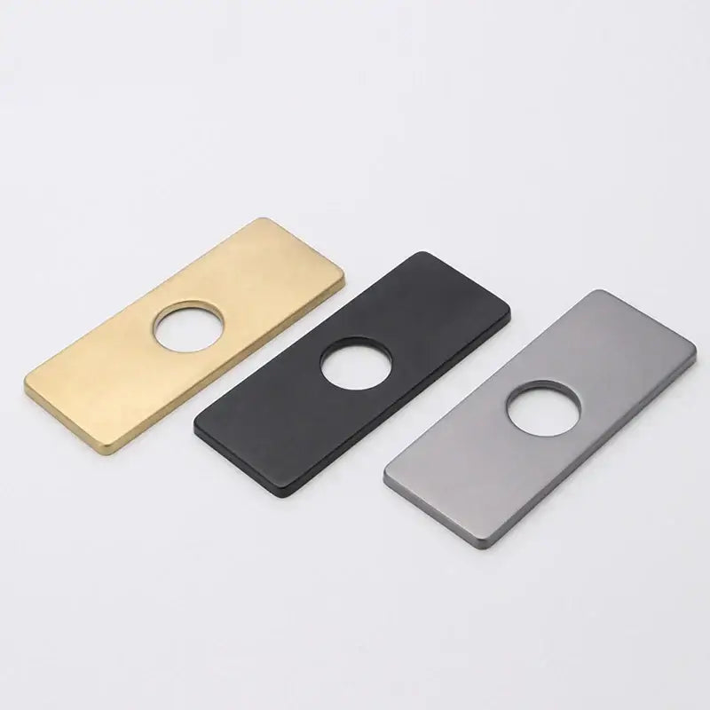 Three rectangular metal cover deck plates in gold black and brushed silver with central circular hole for kitchen faucet