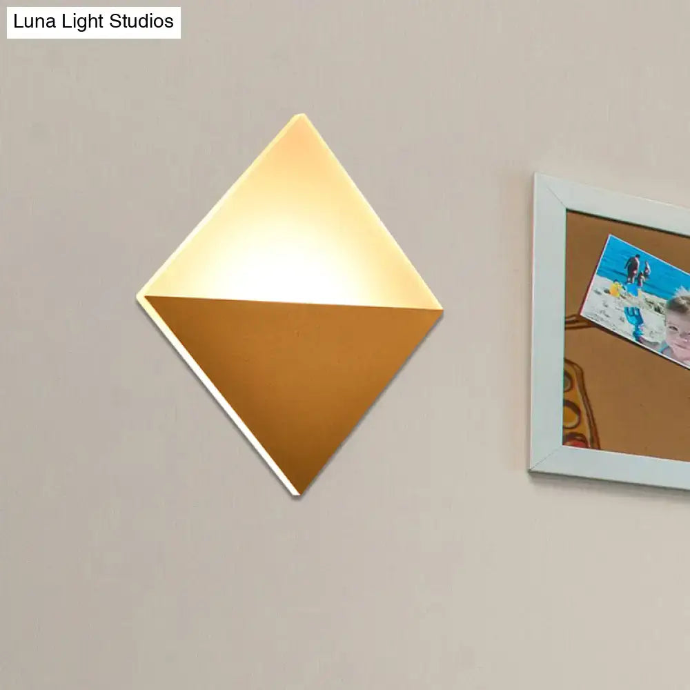 Modern gold and black wall sconce with a two-tone warm gold and matte bronze design and fixture width for bedroom use