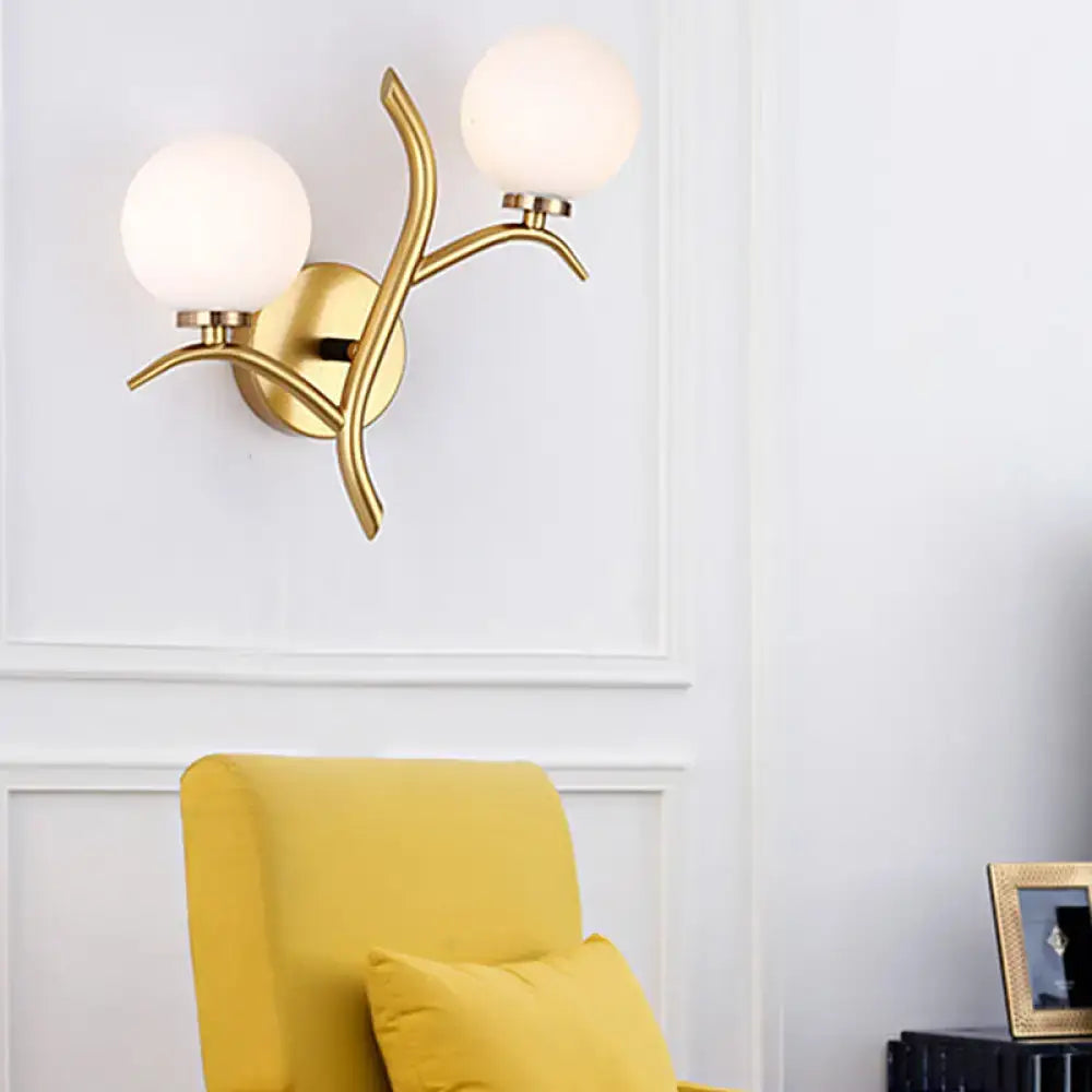 Modern gold branch wall light fixture with two frosted glass globes and organic design for living room sconce