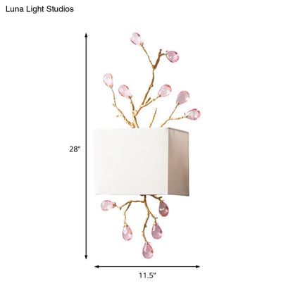 Modern gold branch wall sconce with pink crystal accent and white fabric square lampshade for bedroom lighting