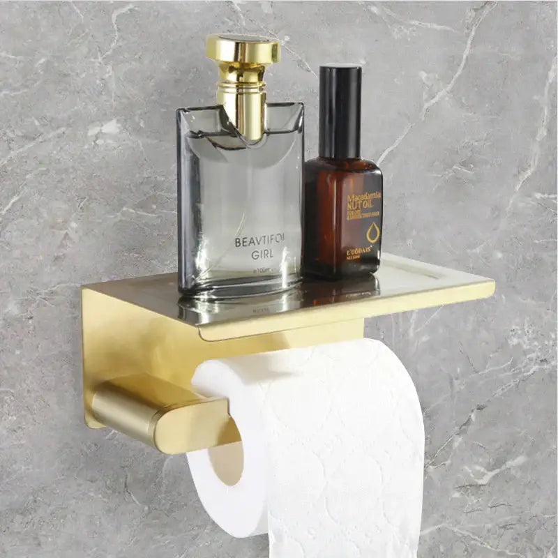 Modern gold brushed bathroom accessories set featuring a gold-toned shelf with integrated toilet paper holder decorbites bathroom