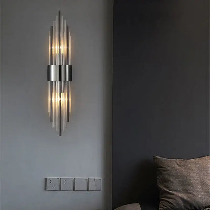 Modern gold and brushed steel wall lamp with sleek metallic frame and vertical glass rods emitting warm light decorbites gold led