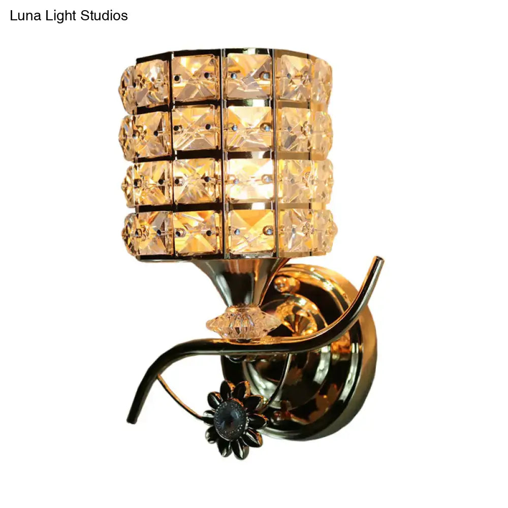 Modern gold wall light fixture with cylindrical crystal shade and floral base for living room sconce lighting