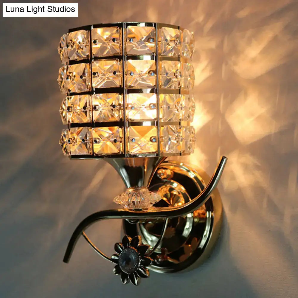 Modern gold butterfly wall light fixture featuring a gold-toned cylindrical crystal shade and decorative floral accent