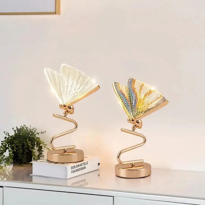 Two modern gold butterfly led pendant lamps with illuminated fan-like wings in white clear and rainbow mosaic designs