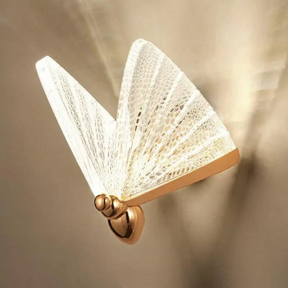 A delicate white butterfly wall lamp with gold-toned base and lace detailing for modern bedroom decorbites butterfly wall decor