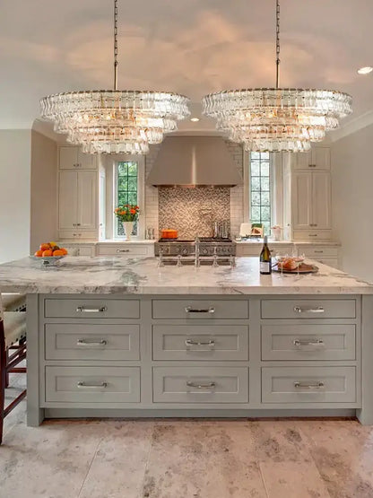 Two large modern gold cascading crystal pendant lights feature multiple tiers of hanging decorbites brown glass pieces