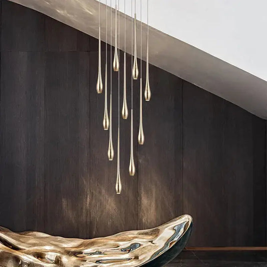 A modern gold-toned led ceiling chandelier with slender teardrop fixtures in a cascading arrangement for living room
