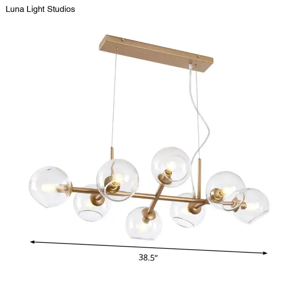 Modern gold pendant chandelier with brass frame and clear glass globes featuring spherical bulbs for dining room lighting