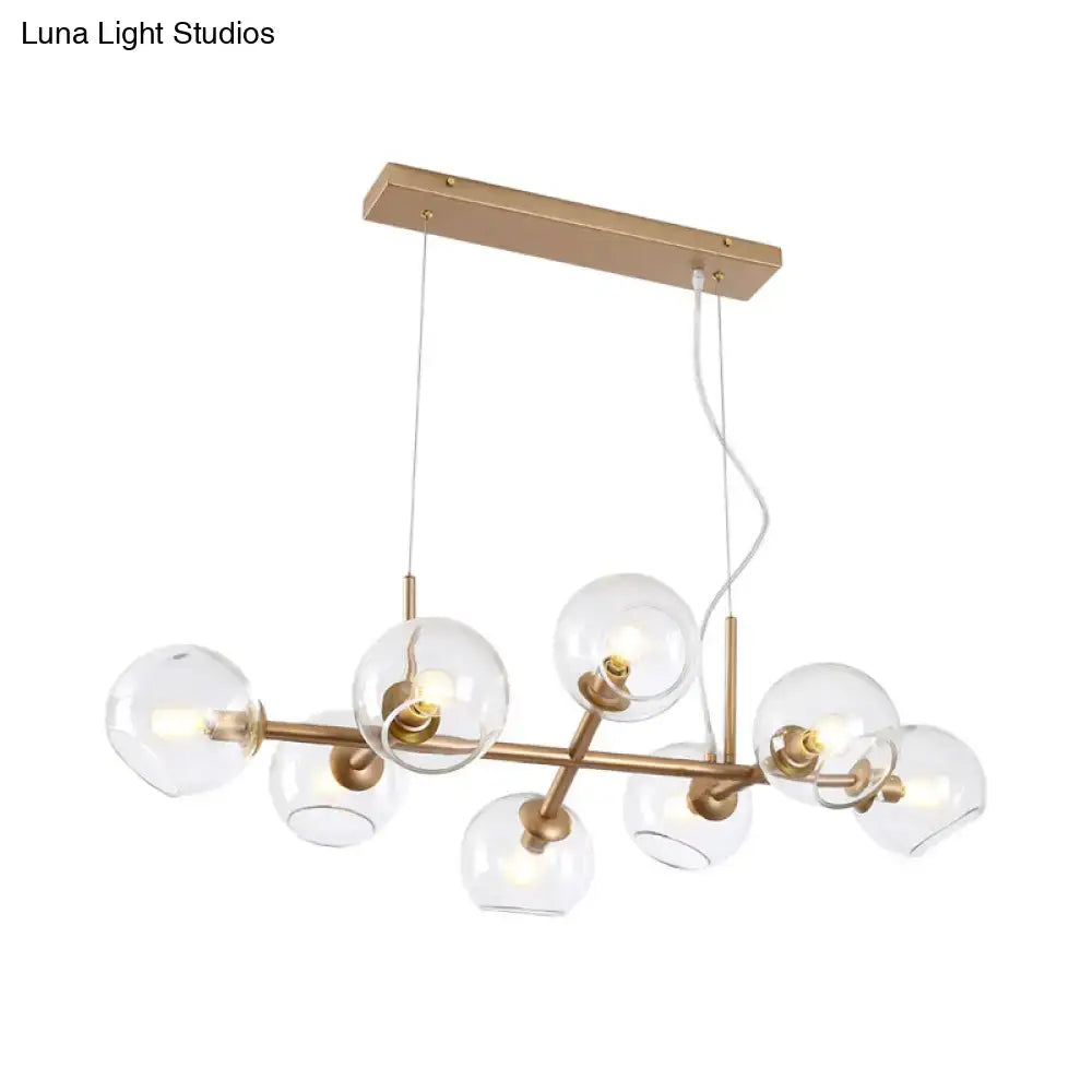 Modern gold brass chandelier with clear glass globe bulbs ideal for dining room lighting and decor