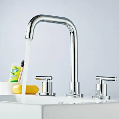 Modern gold and chrome brass basin faucet with chrome curved spout and two handles for hot and cold water use