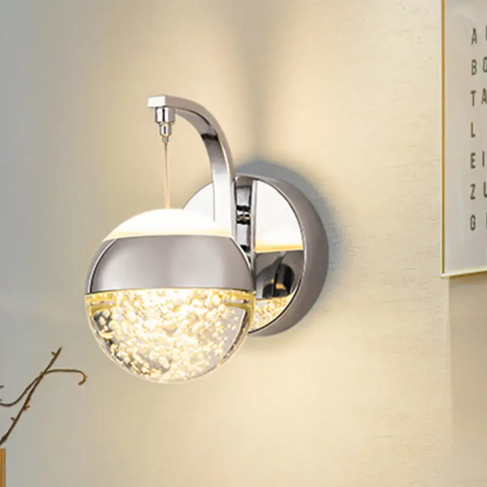 Modern gold and chrome crystal ball wall light with a faceted crystal globe emitting warm light for bedroom lighting