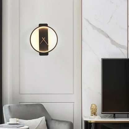 Modern gold circular led wall lamp wall clock with black frame warm glowing light and minimalist gold-toned hands