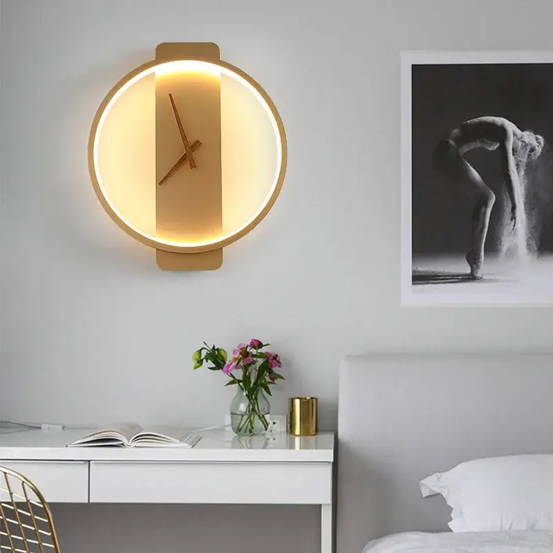 Modern gold circular led wall lamp wall clock with a warm glowing backlight and minimalist hands for bedroom use