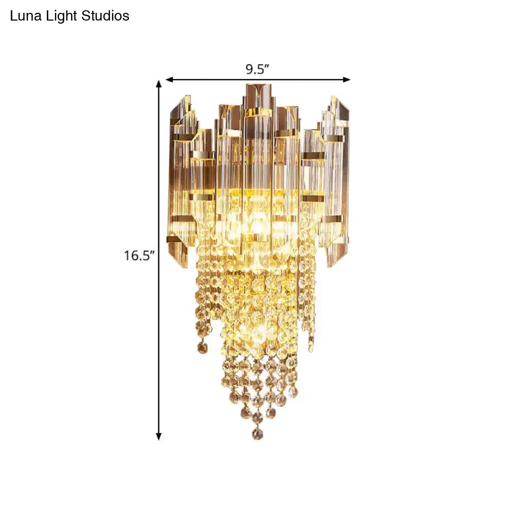 Modern gold wall lamp with clear crystal and amber glass prisms in a cascading tiered sconce design for bedroom use