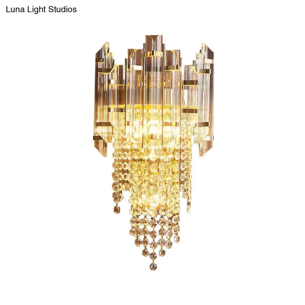 Modern gold wall lamp with clear crystal cascading beads and geometric glass panels for elegant bedroom lighting