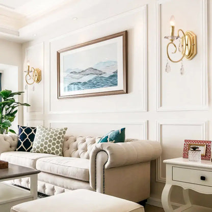 Beige tufted chesterfield sofa with rolled arms and black nailhead trim next to a modern gold clear crystal wall lamp 220v-240v 110v-120v