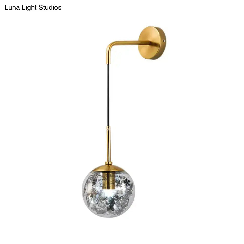 Modern gold wall light with clear glass globe featuring delicate black floral etchings for flower deco cloth decor