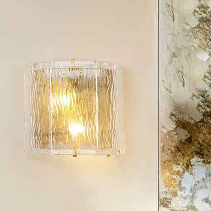 Modern gold clear ripple glass wall sconce with textured wavy ridges and gold-toned metal accents for bedroom wall light