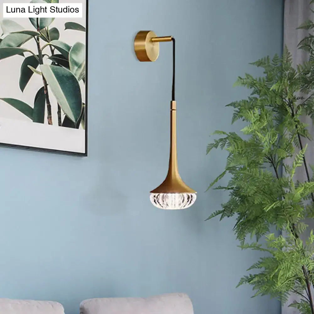 Modern gold wall sconce with a slender stem and clear textured glass crystal-encrusted lampshade for living room