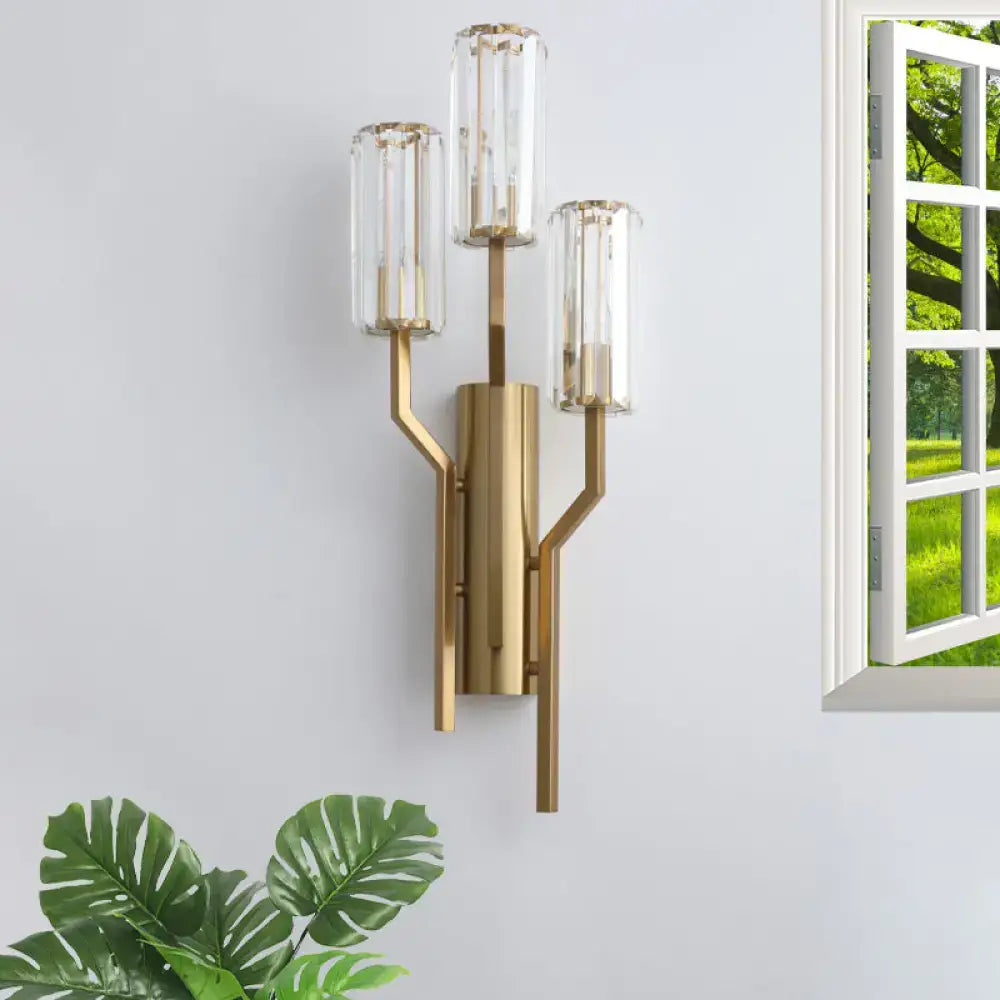 Modern gold-toned crooked arm wall lamp with three clear glass cylinder shades for living room use as a crystal sconce