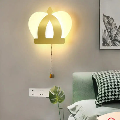 Modern gold crown wall lamp with warm glowing light and pull chain for elegant wall lighting in bedrooms