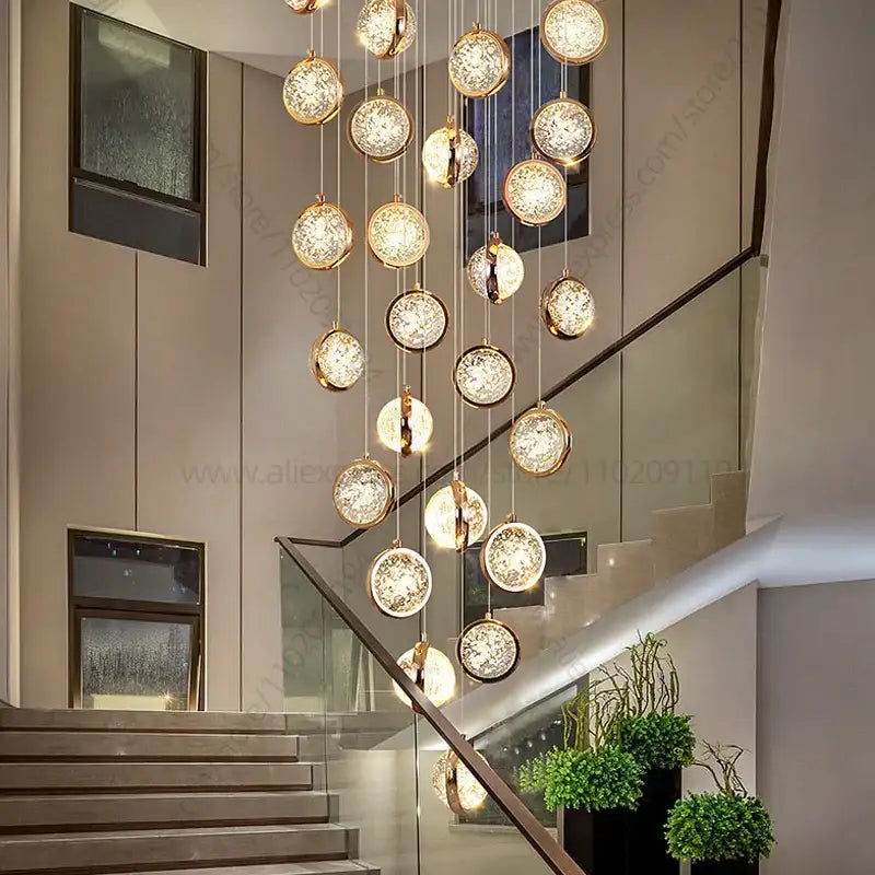 Modern gold crystal ball chandelier with spherical glass orbs suspended in a staircase setting ball chandelier