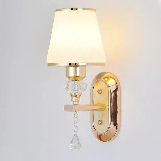 Modern gold crystal bedside wall sconce with cream fabric shade and clear glass bead accents for bedroom lighting