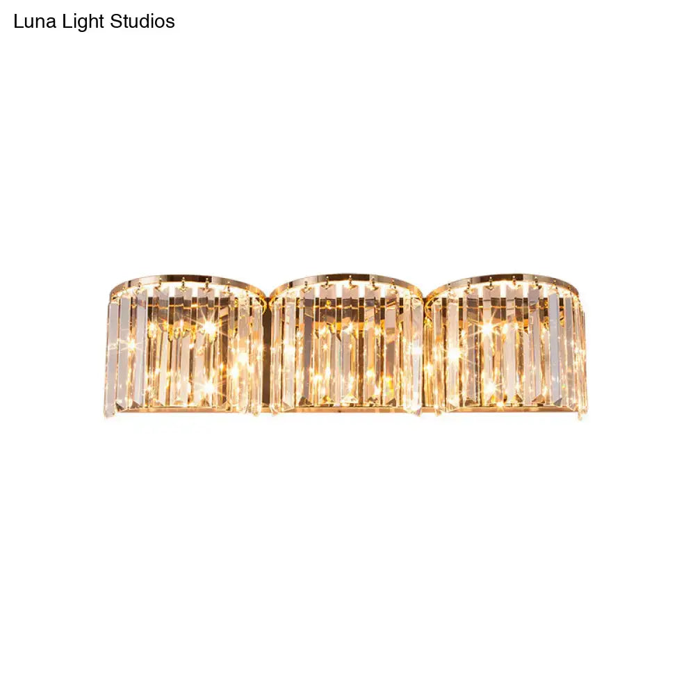 Modern gold crystal block wall light with three cylindrical faceted glass prisms refracting warm light 220v-240v
