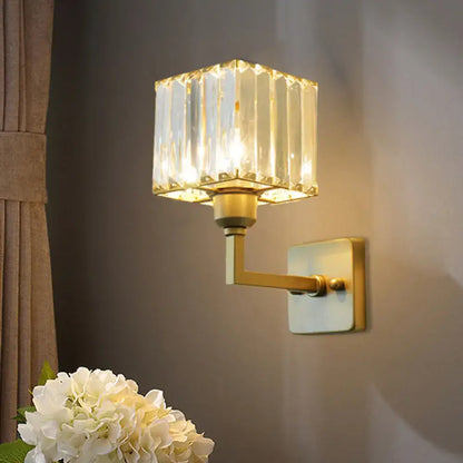 Modern gold crystal block wall sconce featuring a faceted crystal block shade for elegant bedroom lighting
