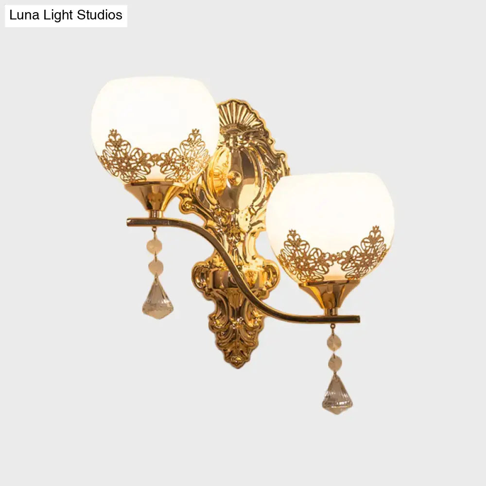 Modern gold crystal bowl wall sconce with two frosted floral cutout shades and dangling teardrop pendants for living room
