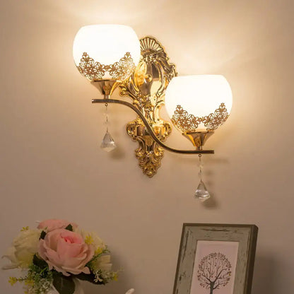 Modern gold crystal bowl wall sconce with two frosted lace cutout shades and dangling crystal teardrops for living room use