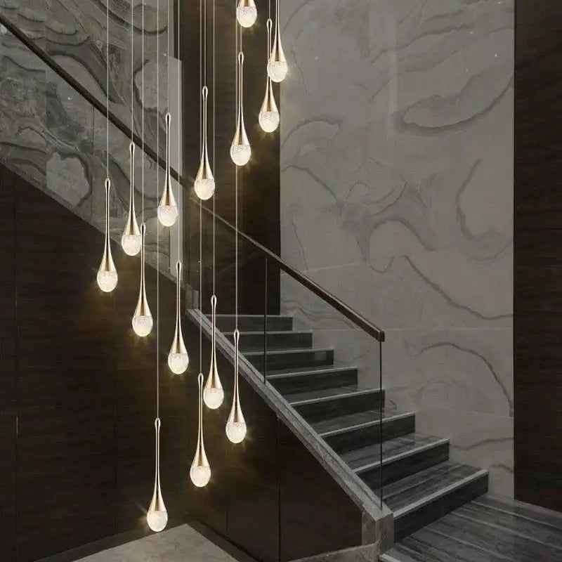 A modern gold crystal bubble chandelier with teardrop glass shades hangs elegantly above a staircase decorbites crystal bubble