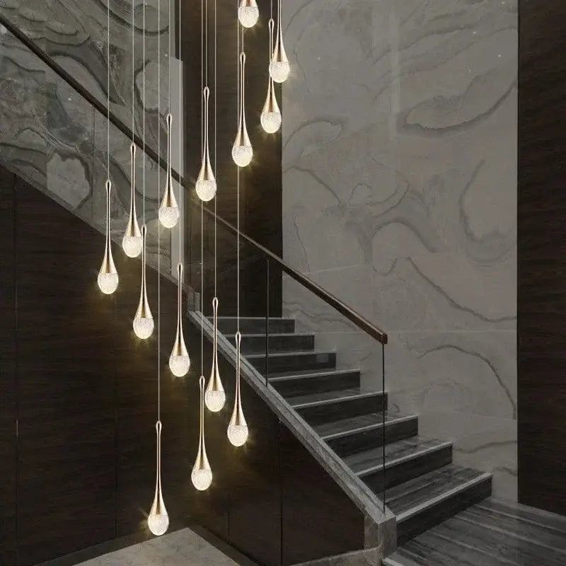 Modern gold crystal bubble chandelier with teardrop glass shades by decorbites hangs above staircase decorbites crystal bubble