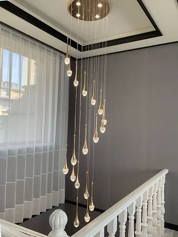 Modern gold crystal bubble chandelier teardrop pendant with crystal accents hanging from circular ceiling fixture