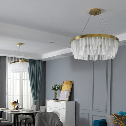 Modern gold crystal ceiling chandelier pendant light with gold-toned frame and cascading clear crystal strands for dining room decorbites